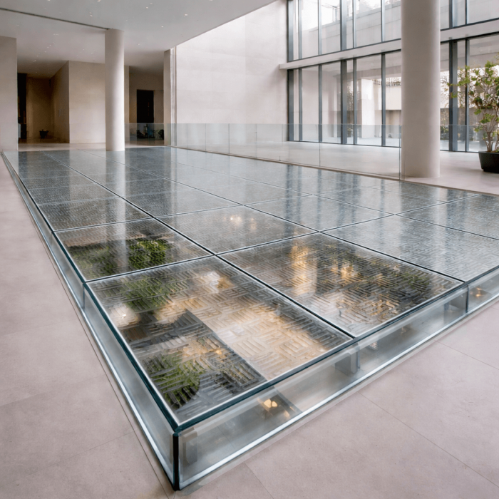 Sol en verre avec motif de grille, éclairé par des lumières intégrées. Un design moderne et fonctionnel, apportant une touche de sophistication à l'espace intérieur.