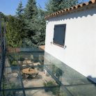 Vue aérienne d'une terrasse en verre trempé avec mobilier extérieur sur un jardin verdoyant