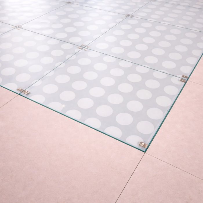 Plancher en verre trempé dépoli (Sablé) de 39 mm avec une texture de grands cercles, diffusant une lumière douce pour une ambiance moderne.