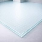 Plancher en verre trempé transparent de 27 mm avec un motif de petits cercles, utilisé pour du mobilier design ou des vitrines décoratives.