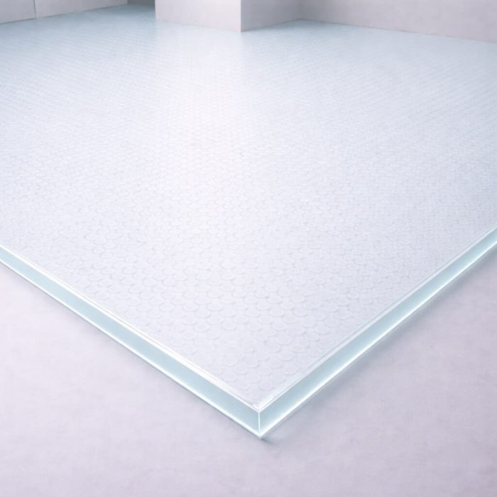 Plancher en verre trempé transparent de 27 mm avec un motif de petits cercles, utilisé pour du mobilier design ou des vitrines décoratives.