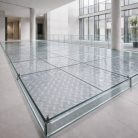 Plancher en verre trempé transparent antidérapant de 33 mm avec texture elliptique, offrant un design fluide et une sécurité optimale.
