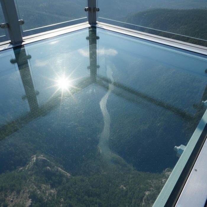 Sol en verre trempé transparent d'un pont suspendu offrant une vue spectaculaire sur la vallée et la nature environnante